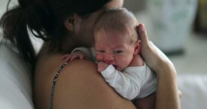 mom holding baby over her shoulder