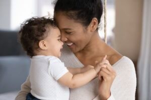 mother holds baby and smiles