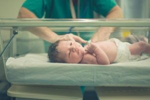A baby being examined by a nurse