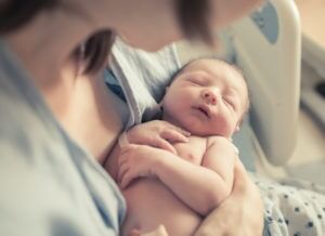 A baby boy rests in his mother’s arms.